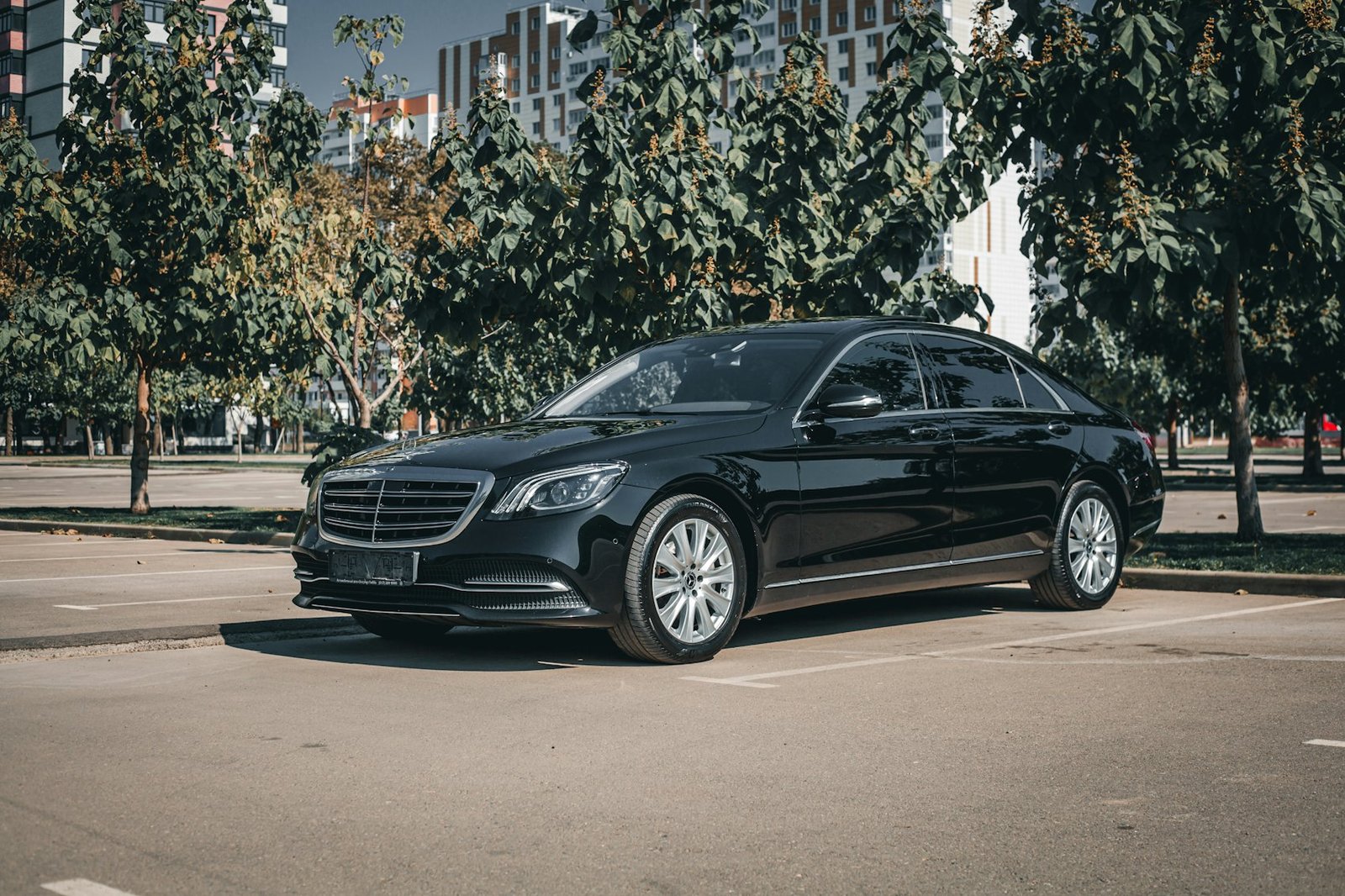 A black executive saloon car parked on a city street