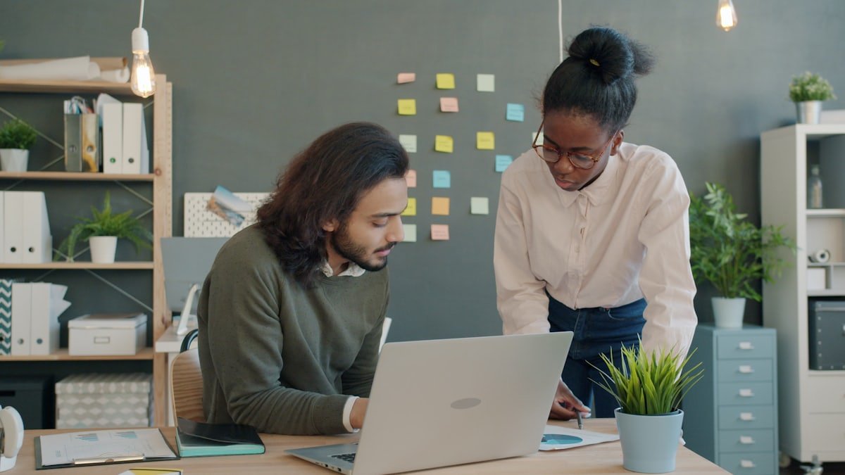 Two colleagues discussing a project together at a desk